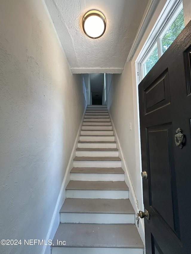 stairway with a textured ceiling