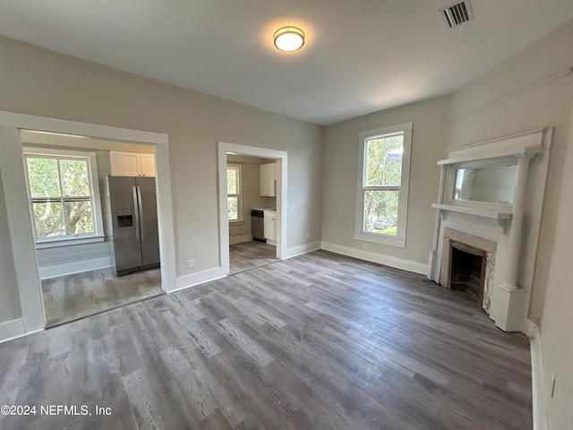 unfurnished living room with a wealth of natural light and light hardwood / wood-style floors