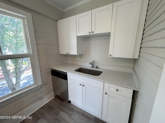 kitchen featuring white cabinetry, dishwasher, sink, and wood walls