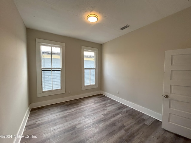 unfurnished room featuring wood-type flooring and a textured ceiling