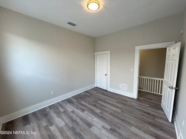 unfurnished bedroom with dark wood-type flooring and a closet