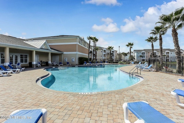 pool featuring a patio, fence, and a residential view