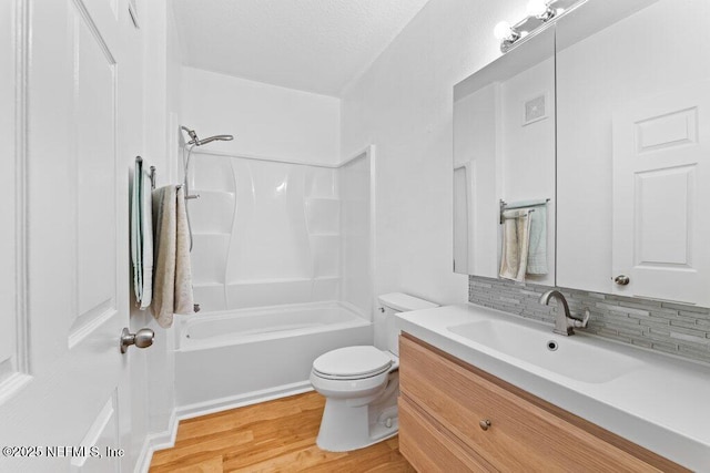 bathroom featuring shower / bath combination, visible vents, toilet, vanity, and wood finished floors