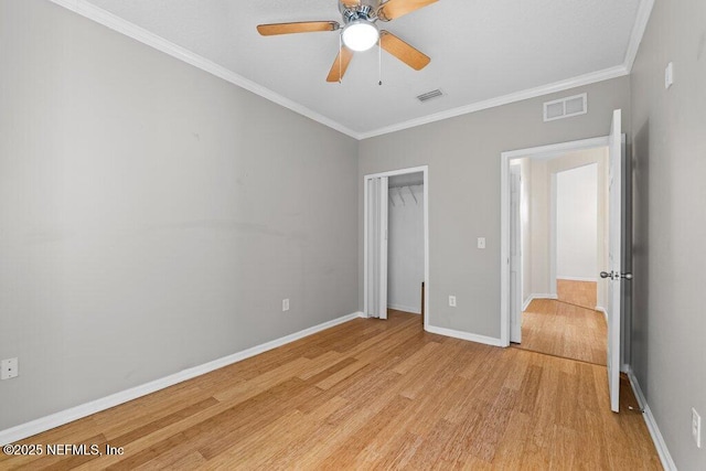 unfurnished bedroom with ornamental molding, light wood finished floors, and visible vents