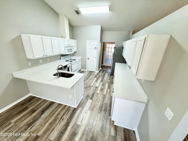 kitchen featuring white cabinetry, sink, white appliances, and light hardwood / wood-style floors