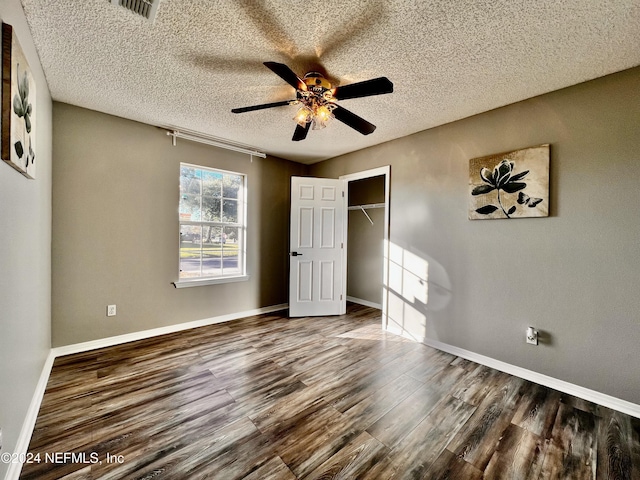 unfurnished bedroom featuring ceiling fan, wood-type flooring, a closet, and a textured ceiling