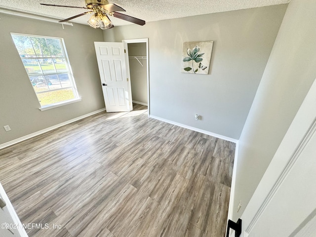 unfurnished room featuring wood-type flooring, ceiling fan, and a textured ceiling