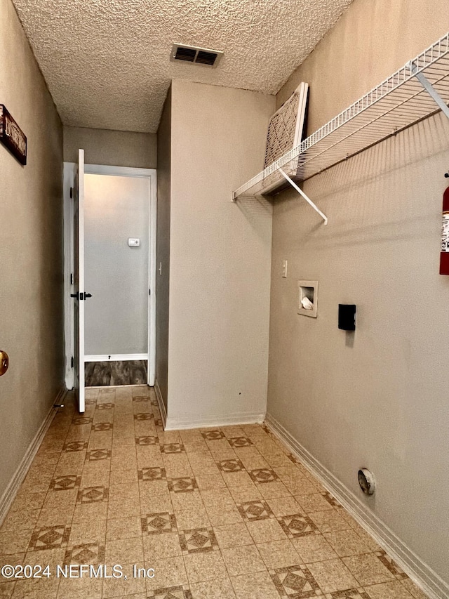 laundry area featuring hookup for a washing machine and a textured ceiling