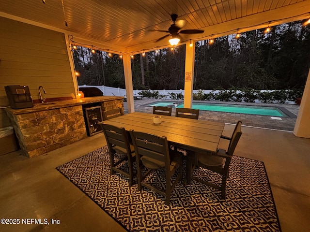 view of patio with ceiling fan, area for grilling, beverage cooler, and sink