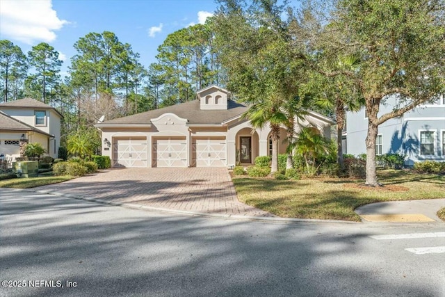 view of front of house with a garage, decorative driveway, and stucco siding