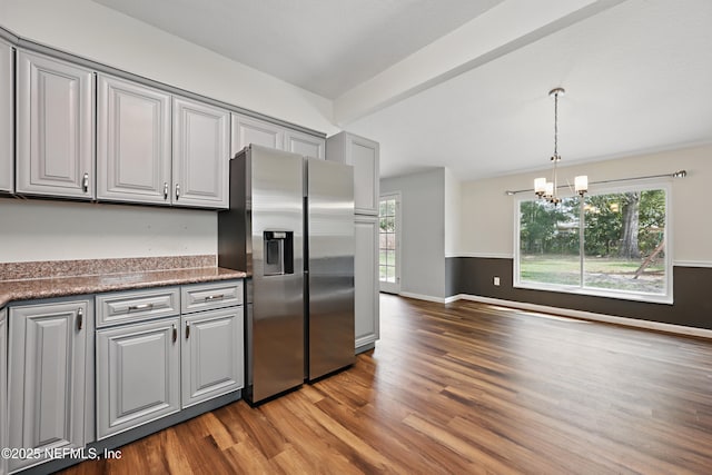 kitchen with a healthy amount of sunlight, stainless steel fridge, gray cabinets, and light hardwood / wood-style flooring