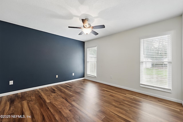 unfurnished room with dark wood-type flooring and ceiling fan