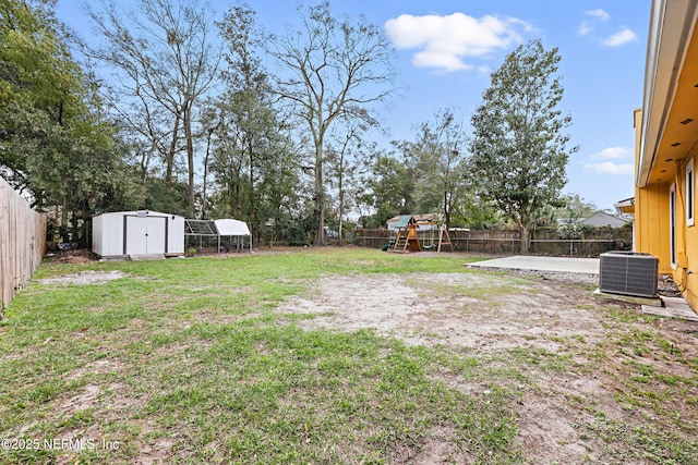 view of yard featuring a storage shed, a playground, a patio area, and central air condition unit