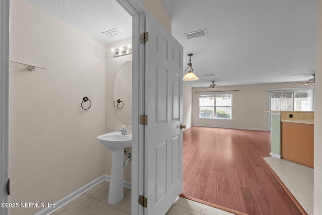 bathroom featuring tile patterned flooring, a textured ceiling, and ceiling fan