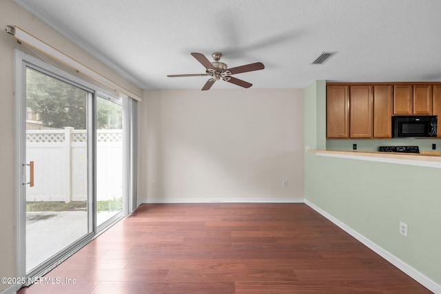 interior space featuring hardwood / wood-style floors, a textured ceiling, and ceiling fan