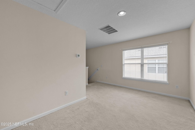 carpeted spare room featuring a textured ceiling