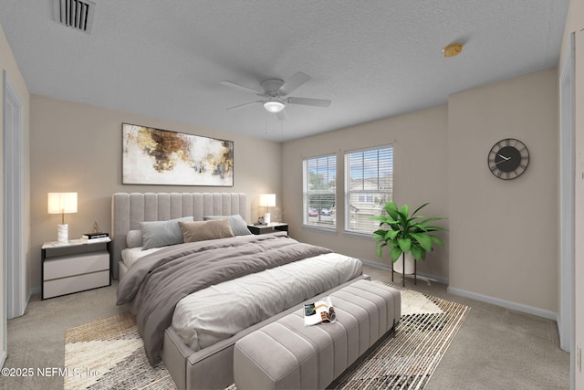 carpeted bedroom featuring ceiling fan and a textured ceiling