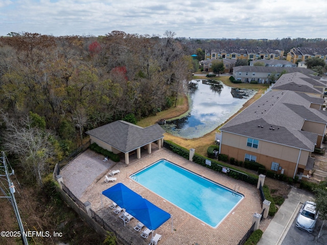 view of swimming pool featuring a patio and a water view