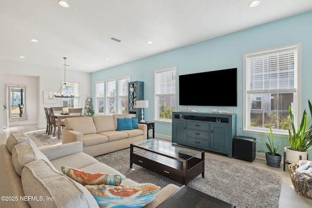 living area with visible vents, recessed lighting, light wood-style floors, an inviting chandelier, and baseboards