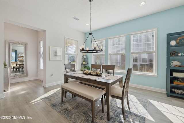 dining area featuring visible vents, baseboards, recessed lighting, light wood-style flooring, and an inviting chandelier