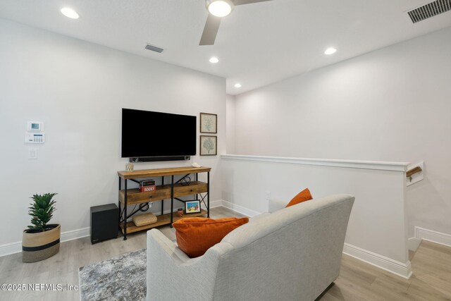 living room featuring visible vents, baseboards, and wood finished floors