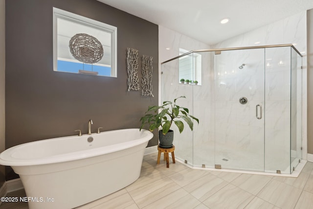 bathroom featuring a soaking tub, a shower stall, baseboards, and lofted ceiling