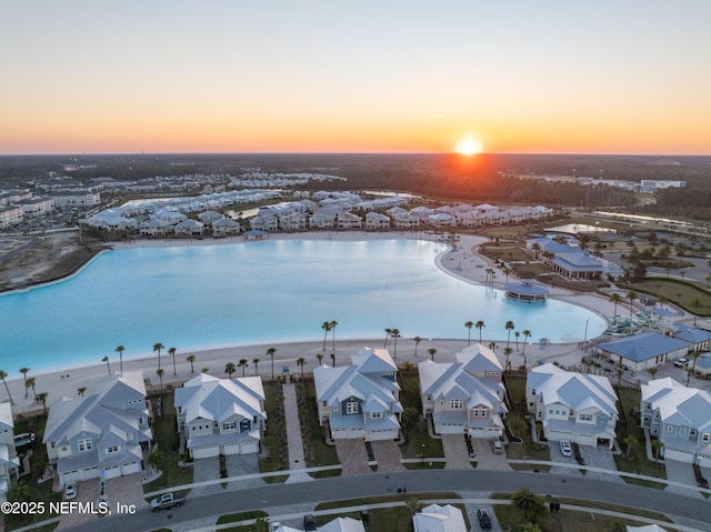 aerial view at dusk with a residential view and a water view