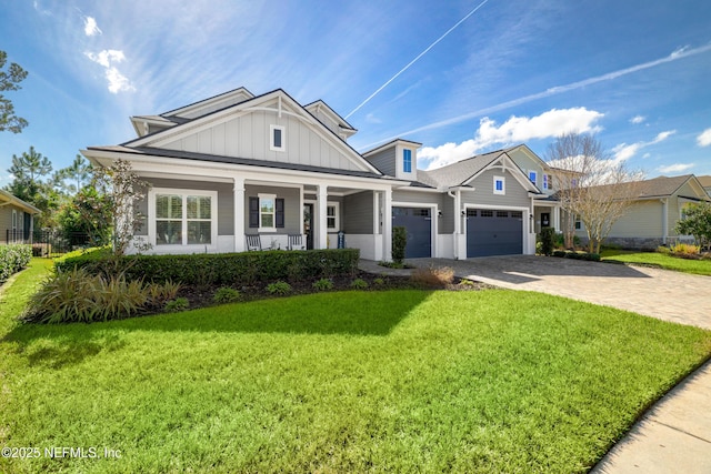 view of front of house featuring a porch, a garage, and a front yard