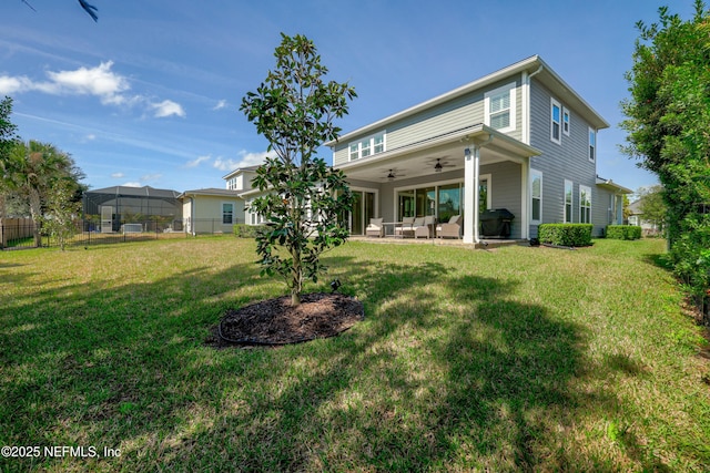 back of property with a patio, ceiling fan, and a lawn