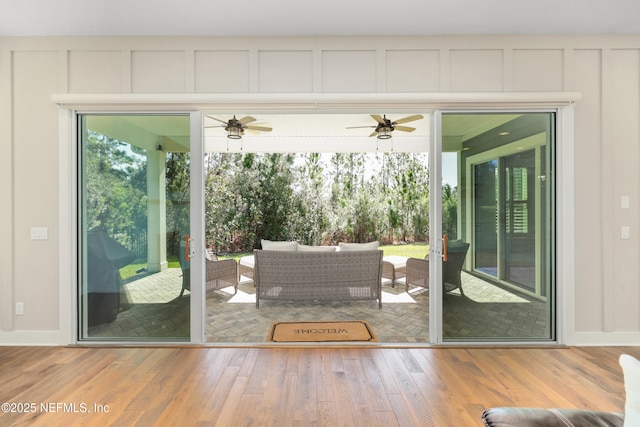 doorway to outside featuring wood-type flooring and ceiling fan