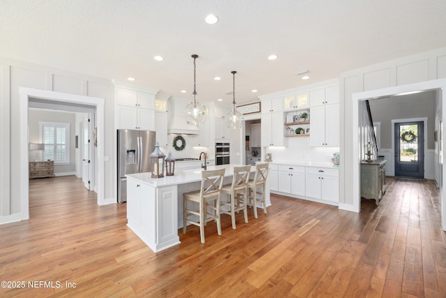 kitchen featuring white cabinetry, a center island with sink, and appliances with stainless steel finishes