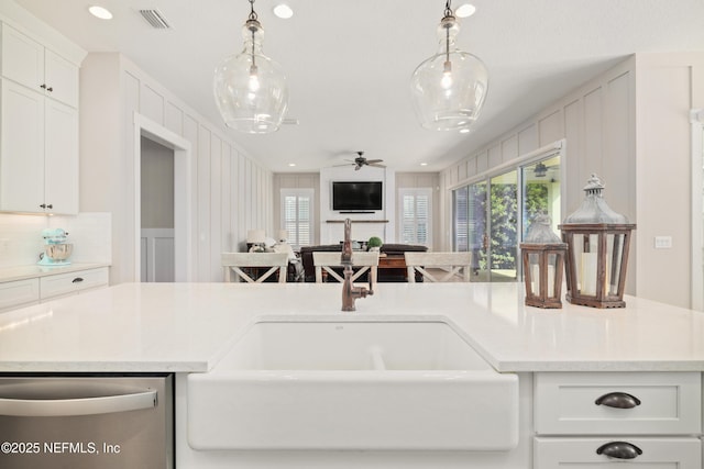 kitchen featuring decorative light fixtures, plenty of natural light, and white cabinets