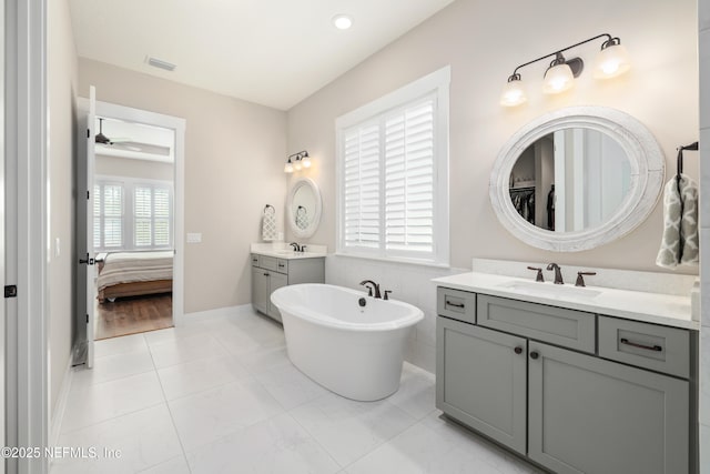 bathroom with ceiling fan, vanity, tile patterned flooring, and a washtub