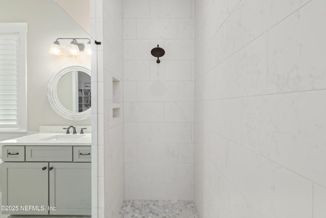 bathroom with vanity and a tile shower