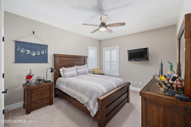 bedroom with light carpet, ceiling fan, and a textured ceiling