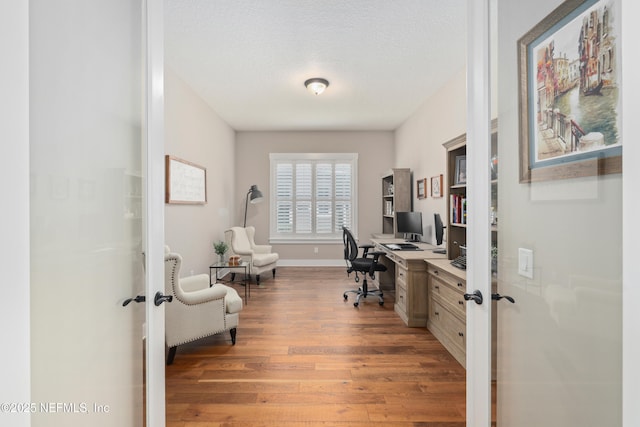 office space featuring dark hardwood / wood-style flooring, french doors, and a textured ceiling