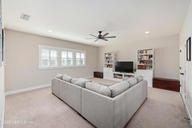 carpeted living room with ceiling fan and a textured ceiling