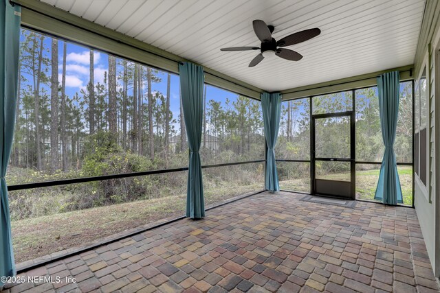 unfurnished sunroom with ceiling fan