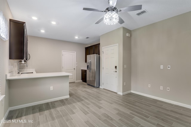 kitchen with light hardwood / wood-style flooring, stainless steel fridge with ice dispenser, dark brown cabinets, and sink