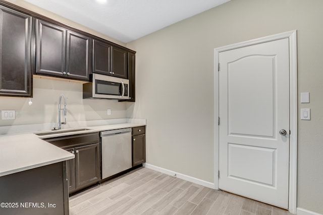 kitchen featuring dark brown cabinetry, sink, and appliances with stainless steel finishes