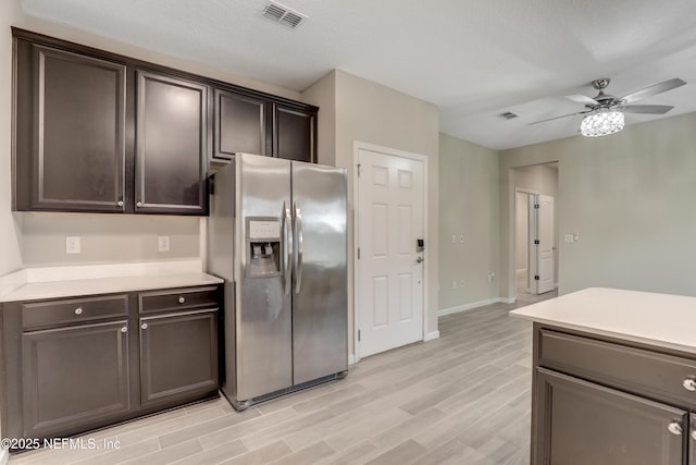 kitchen featuring ceiling fan, dark brown cabinets, stainless steel fridge, and light hardwood / wood-style floors