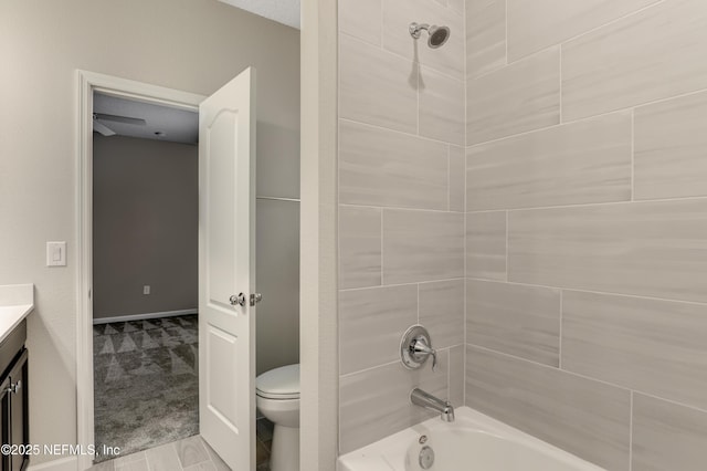 full bathroom featuring tiled shower / bath, vanity, and toilet