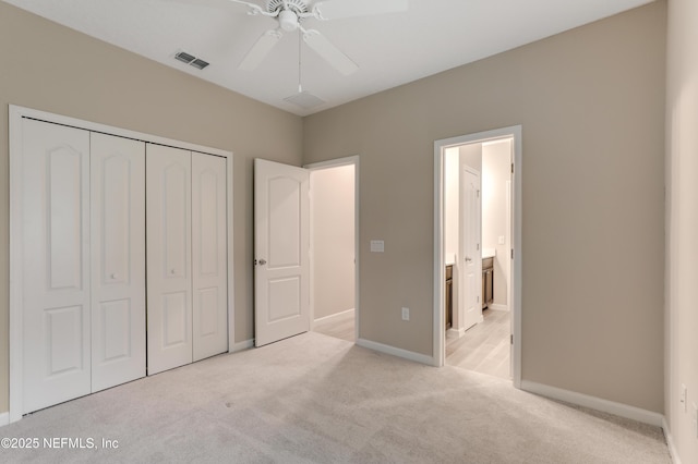 unfurnished bedroom with ceiling fan, a closet, connected bathroom, and light carpet