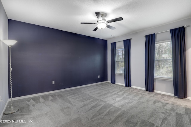 empty room featuring a textured ceiling, carpet floors, and ceiling fan