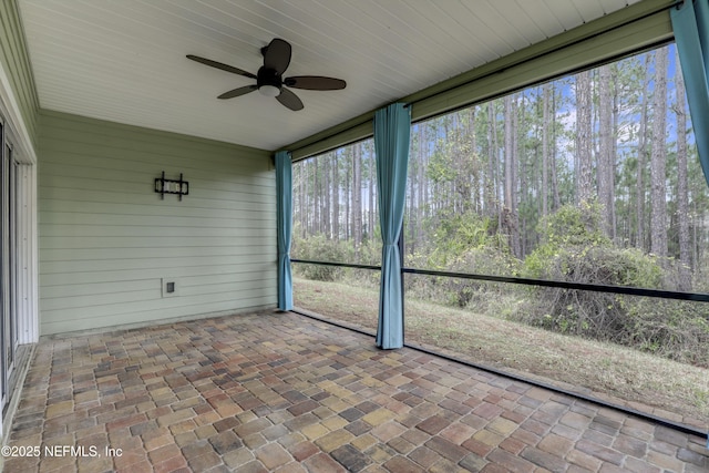 unfurnished sunroom with ceiling fan