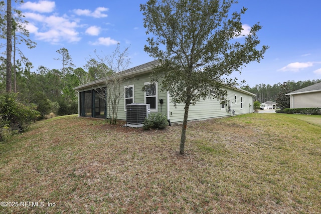 rear view of house featuring a sunroom, a yard, and cooling unit