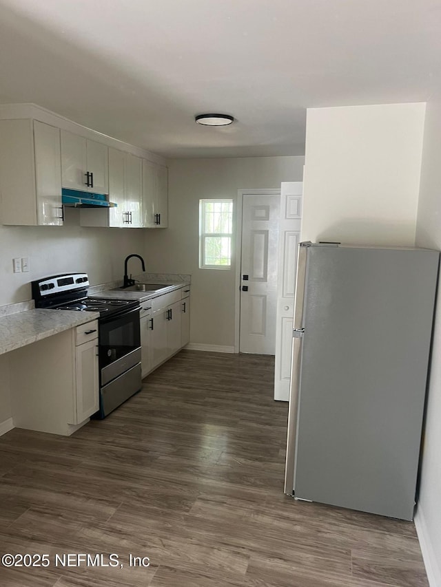 kitchen featuring white cabinets, under cabinet range hood, appliances with stainless steel finishes, and light countertops