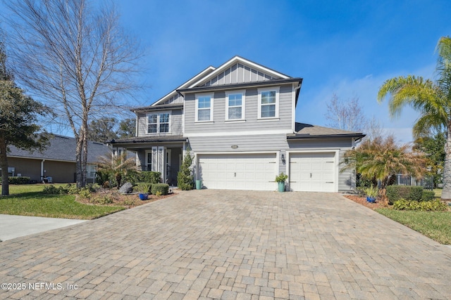 craftsman-style home with decorative driveway, board and batten siding, and an attached garage