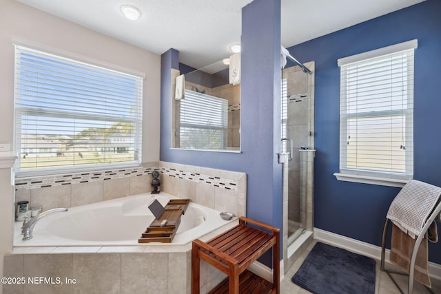 full bath featuring tile patterned flooring, a shower stall, a bath, and baseboards