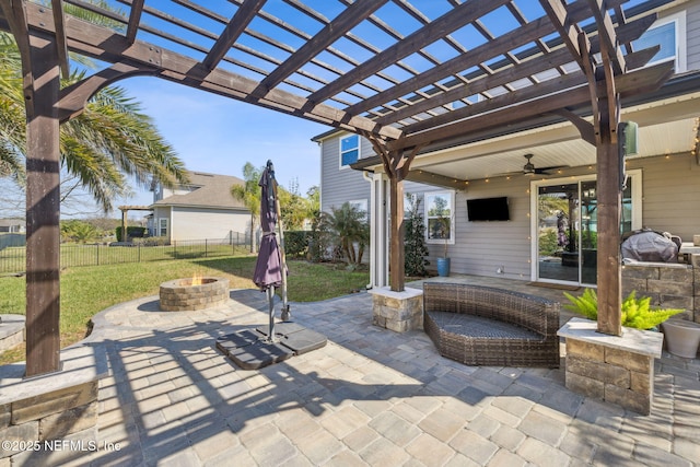 view of patio / terrace featuring a ceiling fan, fence, a fire pit, and a pergola